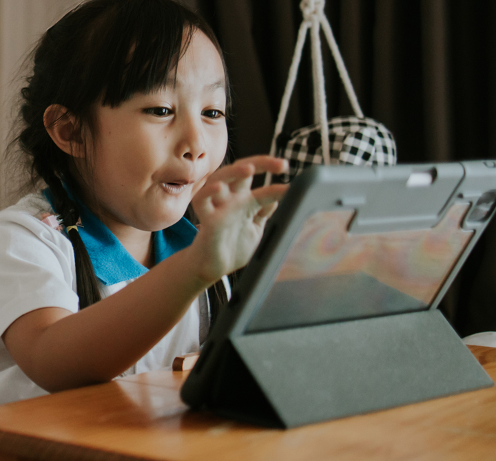 School age student with interacting on a tablet device with excitement